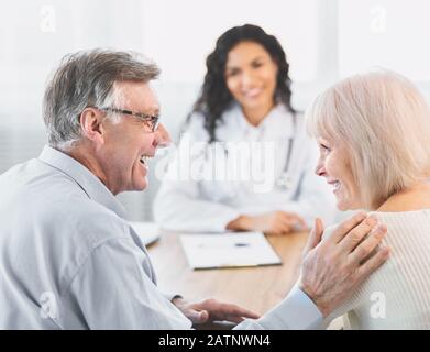 Heureux couple d'âge mûr parlant à leur soignant latin Banque D'Images