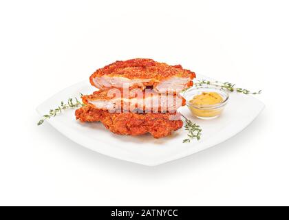 Poulet croustillant chaud sans os pilonné dans une assiette blanche avec moutarde et thym. Viande Croquante Panée Faite De Chiffons De Poulet. Isolé le Banque D'Images