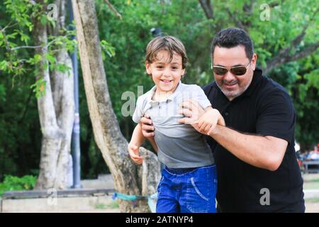 Père et fils jouant heureux dans un parc Banque D'Images