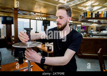 Préparer la shisha, alias nargile ou le hookah dans un restaurant en plaçant la tasse sur le dessus Banque D'Images