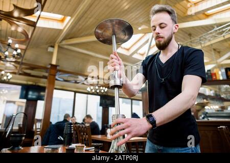 Préparer la shisha, alias nargile ou le hookah dans un restaurant en plaçant la tasse sur le dessus Banque D'Images