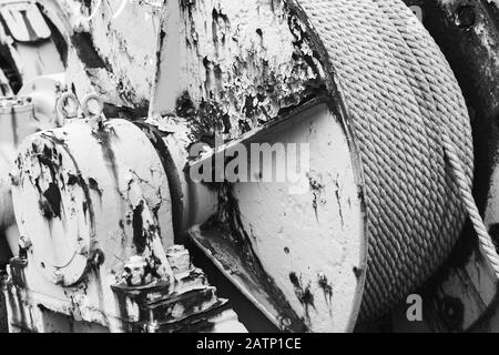 Rouleau de treuil rouillé avec corde en acier, photo en noir et blanc avec mise au point sélective Banque D'Images