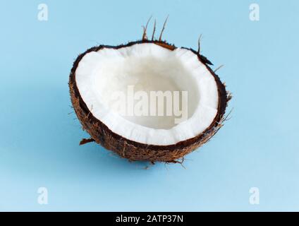 Morceau de noix de coco sur fond bleu clair gros plan Banque D'Images