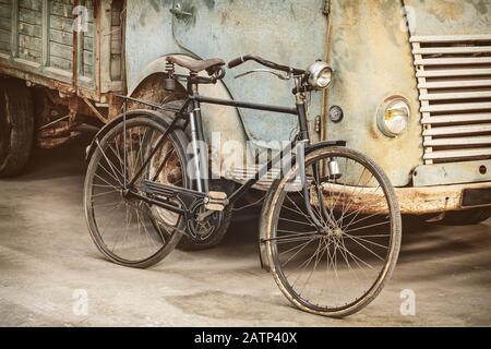 Image de style rétro d'un ancien vélo et d'un camion rouillé dans une grange Banque D'Images