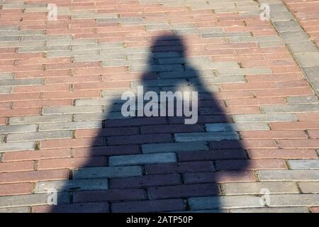 Ombre d'un homme sur le trottoir des tuiles Banque D'Images