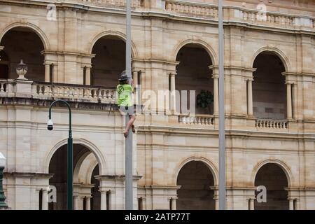 Un manifestant grimpe un flagrant lors de la manifestation à Brisbane.les manifestants de la rébellion de l'extinction se sont vés de perturber la réouverture du Parlement du Queensland à l'extérieur de la Maison du Parlement à Brisbane City pour demander la fin de la corruption gouvernementale, Action urgente en faveur du changement climatique et abandon du soutien à la mine de charbon Adani sur la côte centrale du Queensland. Le groupe de renommée internationale arrête les affaires comme d'habitude en bloquant les routes, en organisant des rassemblements et en perturbant les opérations minières dans un effort pour forcer le changement politique. Banque D'Images