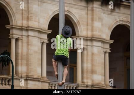 Un manifestant grimpe un flagrant lors de la manifestation à Brisbane.les manifestants de la rébellion de l'extinction se sont vés de perturber la réouverture du Parlement du Queensland à l'extérieur de la Maison du Parlement à Brisbane City pour demander la fin de la corruption gouvernementale, Action urgente en faveur du changement climatique et abandon du soutien à la mine de charbon Adani sur la côte centrale du Queensland. Le groupe de renommée internationale arrête les affaires comme d'habitude en bloquant les routes, en organisant des rassemblements et en perturbant les opérations minières dans un effort pour forcer le changement politique. Banque D'Images