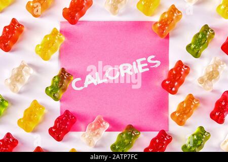 Conception plate de bonbons d'ours gommes avec un papier à note écrit calories dessus. Dépendance au sucre et concept de casse-croûte Banque D'Images