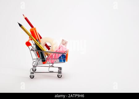 Panier plein de papeterie ou de fournitures de bureau sur fond blanc. Retour au concept scolaire. Banque D'Images