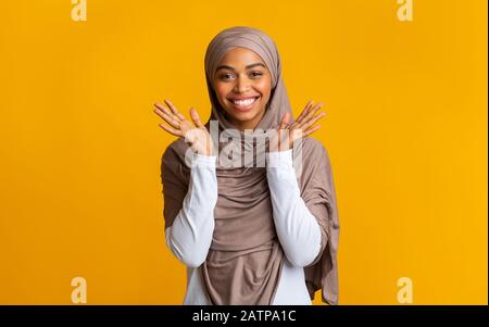 Heureuse fille musulmane noire dans le hijab levant les mains dans l'excitation heureuse Banque D'Images