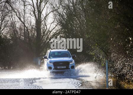 La photo du 27 janvier montre un véhicule roulant sur l'A1101 partiellement inondé à la frontière Cambridgeshire/Norfolk. L'eau inondée le long d'un tronçon de route notoire à Welney, à la frontière Cambridgeshire/Norfolk, a disparu, révélant aujourd'hui QUATRE voitures tordées incroyables (LUN). Les automobilistes ont tous été pris par le long et sinueux tronçon de route, qui a été inondé pendant deux mois. Quatre personnes ont dû être sauvées de l'une des voitures par des pompiers après qu'il a été pris à Welney Wash le 18 janvier. Les voitures abandonnées, qui ont toutes été victimes de la route inondée, seront en mesure d'être Banque D'Images