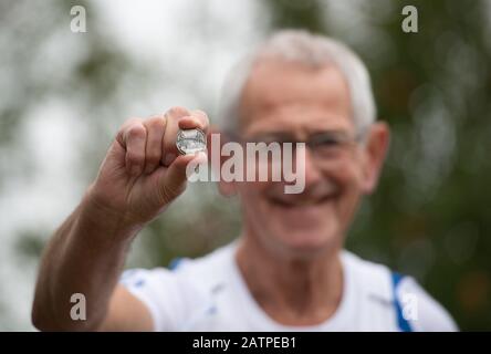 Le marathon de Londres Présente Toujours le coureur Mac Speake, 78 ans, avec sa médaille du tout premier marathon de Londres, chez lui à Kettlebaston près d'Ipswich. Banque D'Images