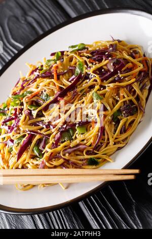 Salade végétarienne de nouilles aux œufs asiatiques avec légumes de saison dans une assiette sur la table. Verticale Banque D'Images