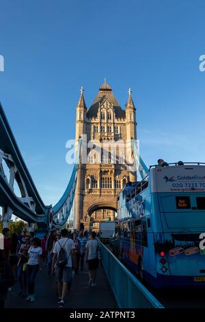 Londres, Angleterre - 17 septembre 2018 : Tourisme marchant sur Tower Bridge au coucher du soleil, à côté d'un embouteillage pendant l'heure de pointe Banque D'Images