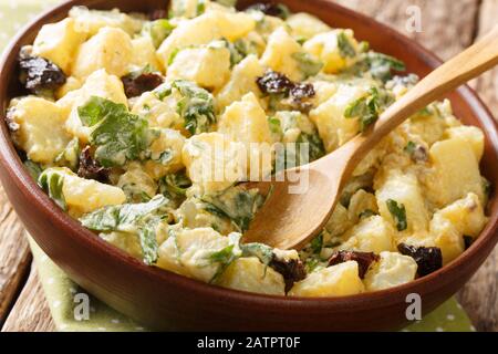 Maroc cuisine salade de pommes de terre avec yaourt, herbes, épices et olives séchées près dans un bol sur la table. Horizontal Banque D'Images