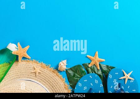 Accessoires de plage avec chapeau de paille et coquillages sur le fond vue de dessus avec espace de copie. Banque D'Images