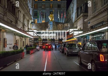 The Savoy Hotel à Londres la nuit sur le Strand avec des taxis noirs garés Banque D'Images