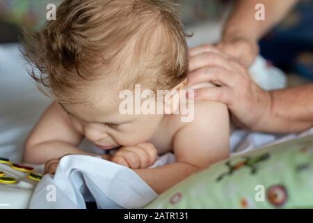 Bébé avec paralysie cérébrale ayant un massage du dos dans un centre de réadaptation. Petit enfant en thérapie. Massothérapeute massant un bébé de besoins particuliers. Banque D'Images