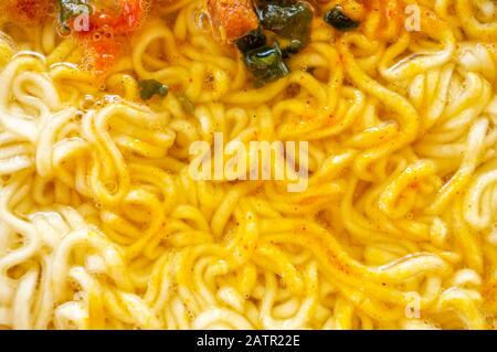 bol de soupe de ramen. Tom Yam kun nouilles instantanées avec de la viande séchée et des additifs végétaux sur une table en bois. Soupe rapide préparée à chaud dans un emballage jetable Banque D'Images