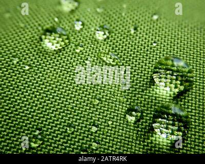 Gouttes de pluie sur fond vert texturé. Banque D'Images