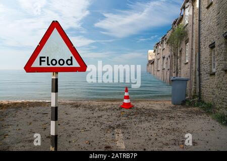 image conceptuelle inondation de la route en raison du changement climatique avec un panneau de signalisation en premier plan Banque D'Images