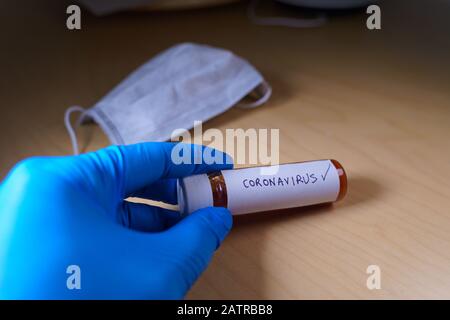 Un médecin étiquetant un tube d'échantillon de sang positif avec le coronavirus Banque D'Images
