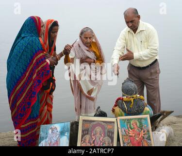 Les dévotés en pèlerinage paient leur respect et leurs offrandes votives aux dieux hindous le long de la rive de la rivière à l'aube à Vrindavan, Uttar Pradesh, Inde. Banque D'Images