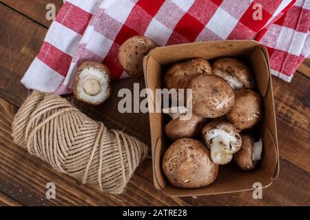 Bébé bella champignons à l'intérieur du bac en papier sur table en bois Banque D'Images