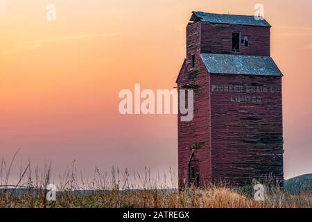 Silo à grains abandonné et abîmé au coucher du soleil sur les Prairies canadiennes; Val Marie, Saskatchewan, Canada Banque D'Images