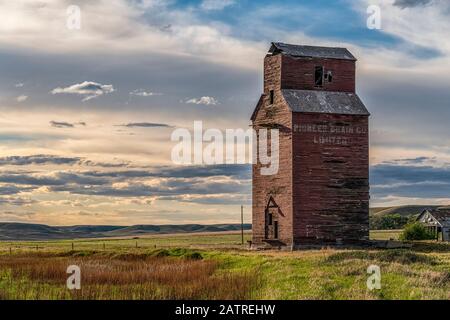 Silo à grains abandonné et abîmé au coucher du soleil sur les Prairies canadiennes; Swift Current, Saskatchewan, Canada Banque D'Images