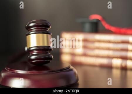 Le gavel du juge avec des livres et un plafond de graduation sur le fond Banque D'Images