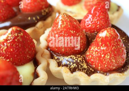 Gros tartes aux fraises fraîches et appétissantes avec poudre d'or comestible Banque D'Images