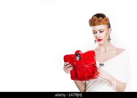 Portrait de jeune pauvre mécontent de beauté couronnée reine frustrée femme tenant regardant dans son sac portefeuille heureux regarder dans lui, n'ayant pas d'argent Banque D'Images