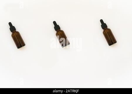 Motifs de bouteilles en verre de cosmétiques faits maison. Concept de médecine naturelle. Pots avec huile essentielle isolés sur un fond blanc. Vue de dessus ou de la couche plate. Banque D'Images