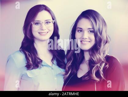 Deux jeunes femmes qui sont amies, posant pour un portrait qui a été modifié numériquement pour un effet vintage: Studio Banque D'Images