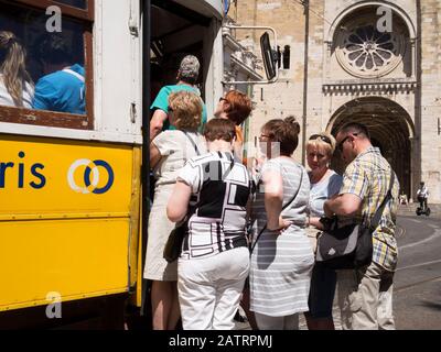 Les touristes prenant le tram 28 devant la cathédrale de Lisbonne à Alfama, Lisbonne. Le tramway numéro 28 de Lisbonne traverse les quartiers touristiques populaires Banque D'Images