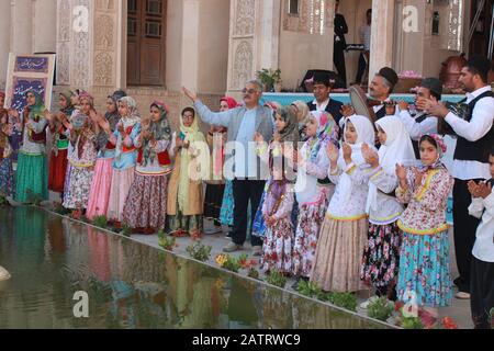 Jeunes filles iraniennes en costumes traditionnels colorés Accompagnés de musique traditionnelle, de bonheur et de clapping, Au Festival des roses de Kashan, Iran Banque D'Images