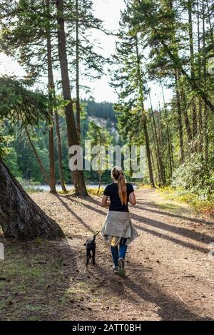 Fille marchant son chien dans un parc; Colombie-Britannique, Canada Banque D'Images