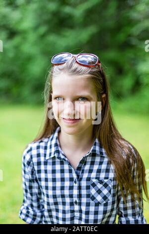 Portrait d'une pré-adolescente debout sur l'herbe dans un parc; Salmon Arm, Colombie-Britannique, Canada Banque D'Images