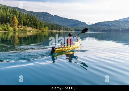 Un adolescent qui fait du kayak sur White Lake, dans le parc provincial de White Lake; Colombie-Britannique, Canada Banque D'Images