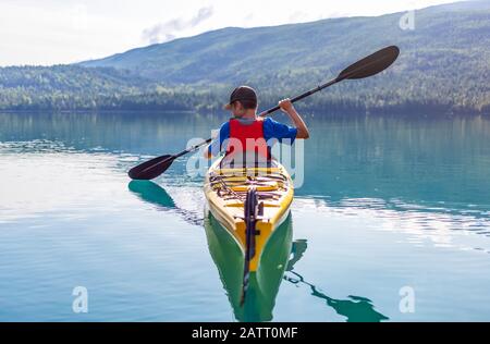 Un adolescent qui fait du kayak sur White Lake, dans le parc provincial de White Lake; Colombie-Britannique, Canada Banque D'Images