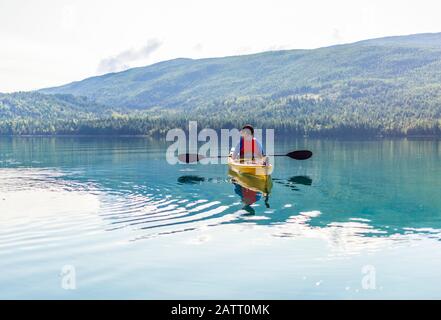 Un adolescent qui fait du kayak sur White Lake, dans le parc provincial de White Lake; Colombie-Britannique, Canada Banque D'Images