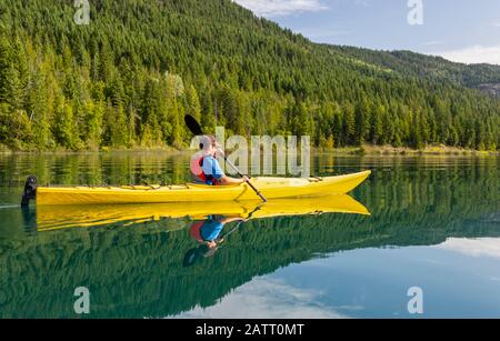 Un adolescent qui fait du kayak sur White Lake, dans le parc provincial de White Lake; Colombie-Britannique, Canada Banque D'Images