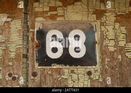 Plaque en métal émaillé de grunge carrée de nombre d'adresses avec le numéro 68 closeup Banque D'Images