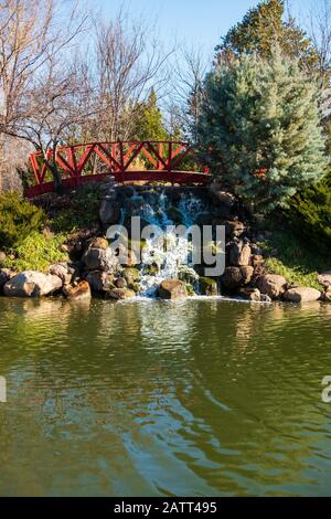 Une attraction aquatique d'une petite passerelle et d'une chute d'eau à côté d'un petit lac au centre commercial Bradley Fair à Wichita, Kansas, États-Unis. Banque D'Images