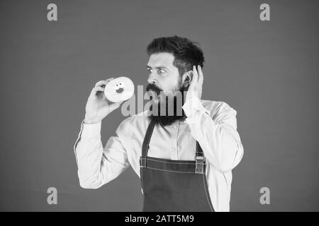 Aucun moyen. Faits sur le sucre. Barbu hippie baker tenir beigne glacé sur fond rouge. Cafe and Bakery concept. Sweet donut de Baker. Barbu homme Baker en tablier de cuisine tenir cute dessert. Banque D'Images