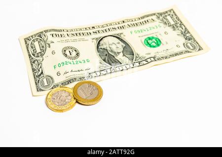 Une livre et une pièce de monnaie en euros et une note en dollar sur fond blanc Banque D'Images