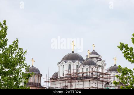 Toits et Cupola d'une église orthodoxe serbe en construction dans la banlieue de Belgrade, en Serbie, avec sa croix dorée et ses échafaudages, symbole Banque D'Images