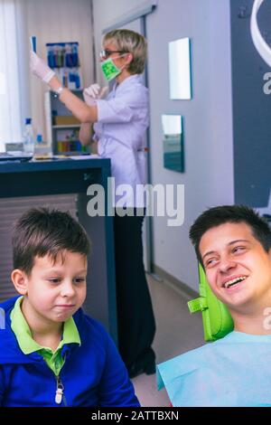 Deux jeunes frères heureux assis dans un bureau de dentiste et attendant un examen dentaire Banque D'Images