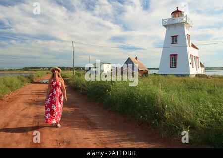 Une femme en robe marchant à côté du phare dans le nord de rustico Î.-P.-É. Canada Banque D'Images